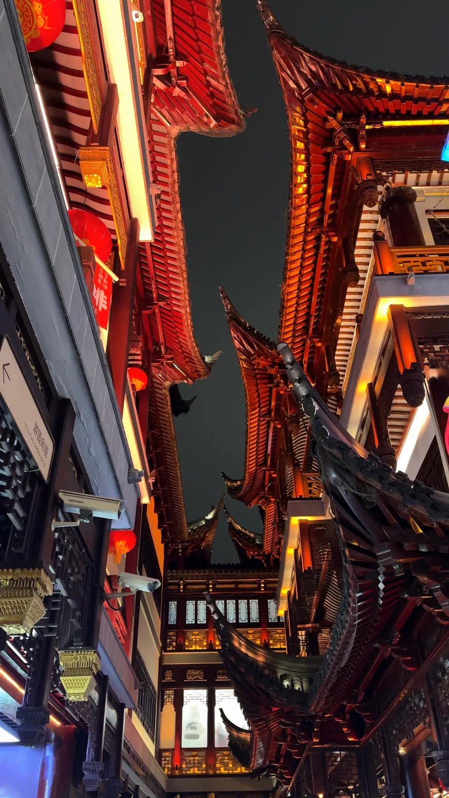 The curved roofs of Yu Garden lit up in red at night